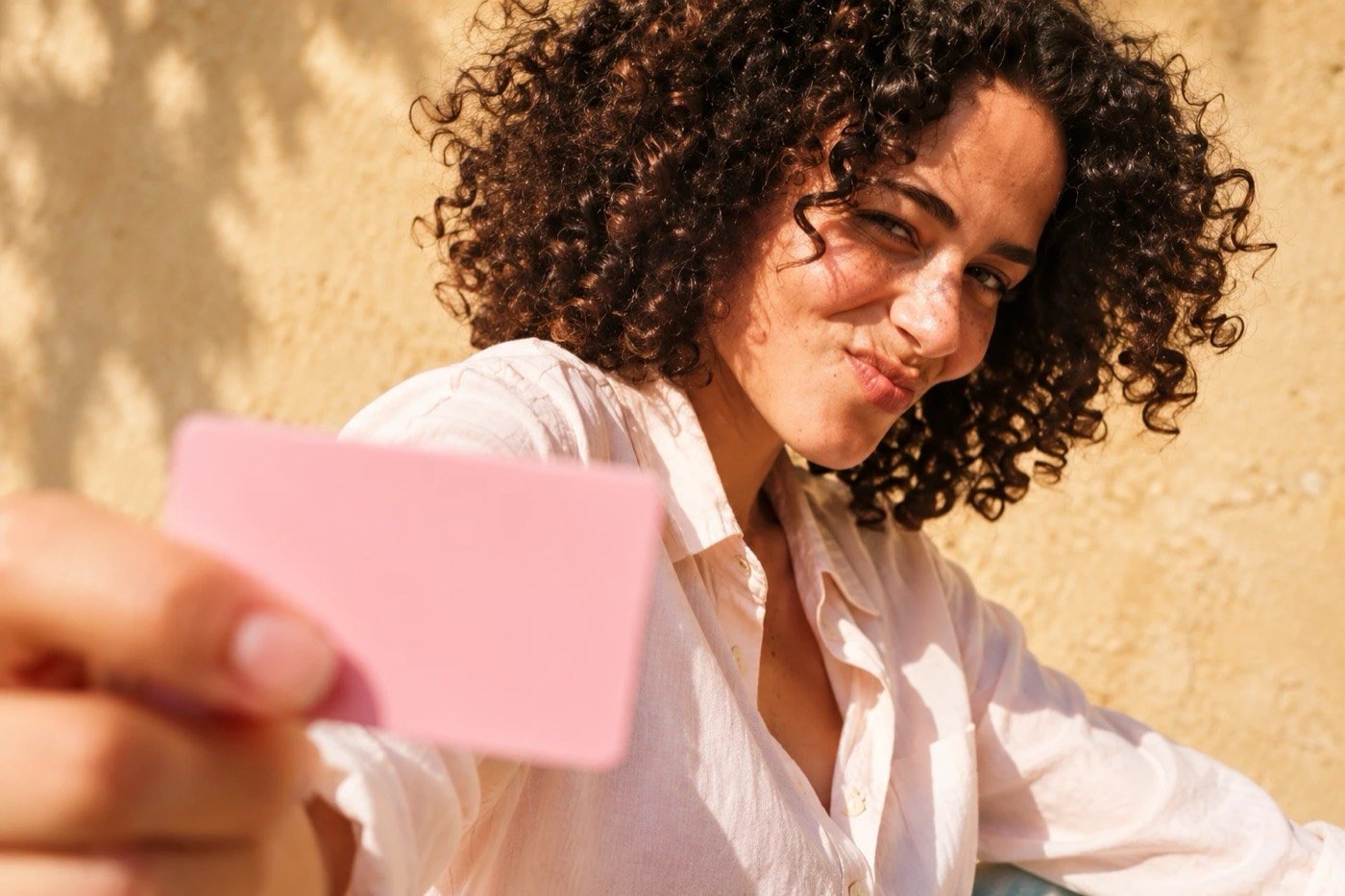 Smiling woman holding out a payment card
